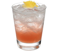 A pink-red cocktail with crushed ice is served in a short glass, with a yellow citrus garnish placed on top.