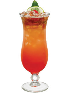 A red orange cocktail with ice is served in a tall stemmed glass and garnished with a lime slice red cherry and green leaf