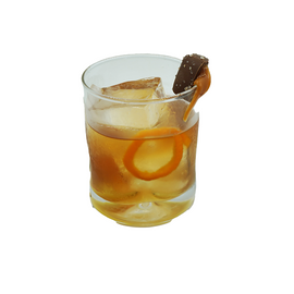 Rocks glass with amber iced drink orange twist chocolate garnish plain background