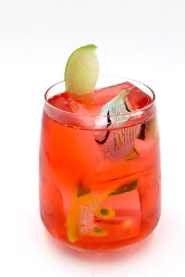 Stemless glass with red drink lime wedge plain background