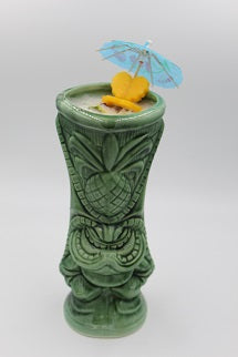 Tiki mug with iced drink fruit garnish paper umbrella plain background