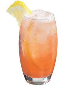 Pink orange cocktail with ice and lemon wedge in a rounded glass on a white background