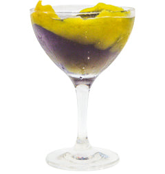 Purple cocktail in a coupe glass with a large lemon peel twist isolated on a white background