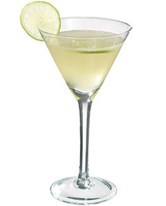 A pale yellow-green cocktail is served in a martini glass and garnished with a lime wheel on the rim.