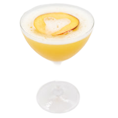 Pale yellow cocktail with foam and peach garnish in a coupe glass
