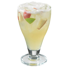 A pale yellow cocktail with ice is served in a tall stemmed glass with red green and pale fruit pieces visible inside the drink