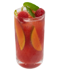 A red cocktail is served in a tall glass with peach slices and raspberries visible inside, garnished with lime slices and fresh mint leaves on top.