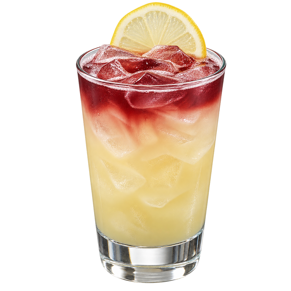 A pale yellow cocktail with ice is served in a short glass with a dark red layer on top and a lime slice garnish on the rim