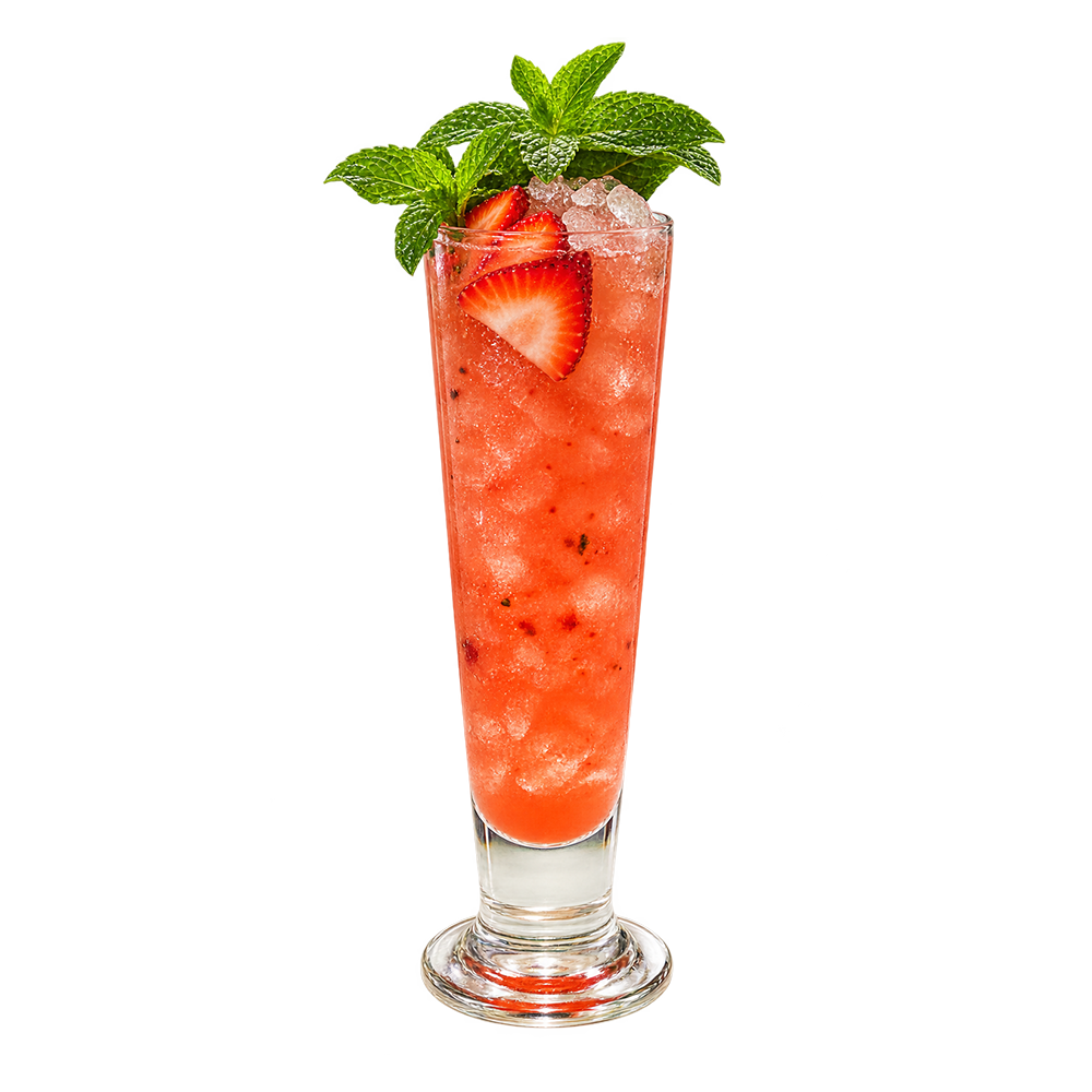 A red strawberry cocktail with ice is served in a tall narrow glass and garnished with sliced strawberries and fresh mint leaves.