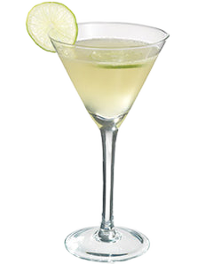 A pale yellow-green cocktail is served in a martini glass and garnished with a lime wheel on the rim.