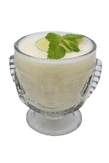 Tiki glass with creamy white drink lime slice mint sprig plain background